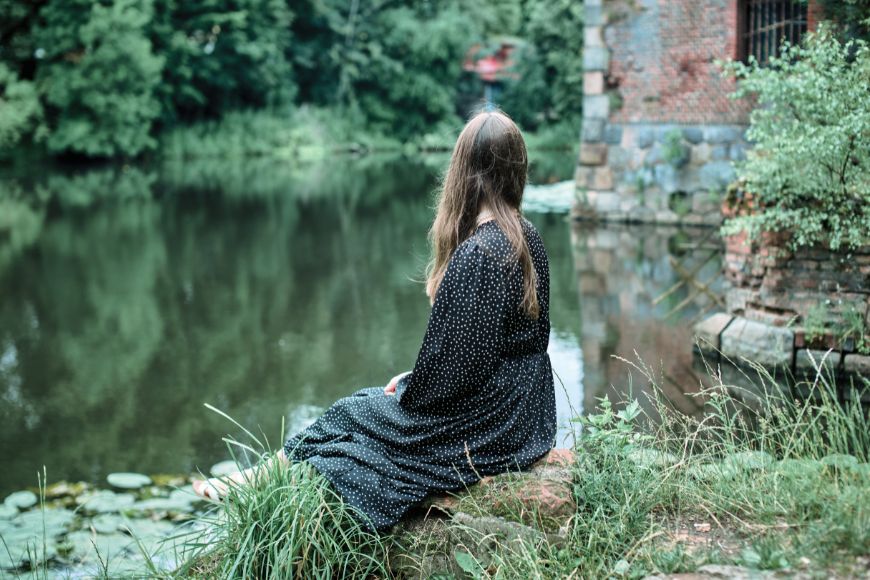 Woman sitting by stream thinking